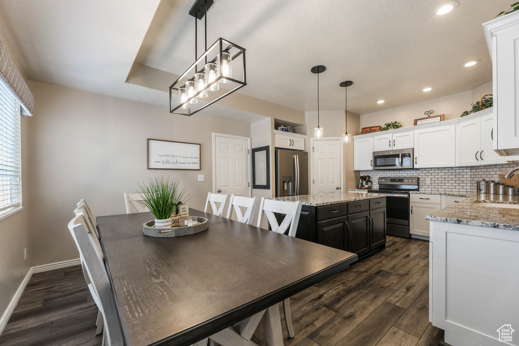 Dining area with dark wood finished floors and recessed lighting