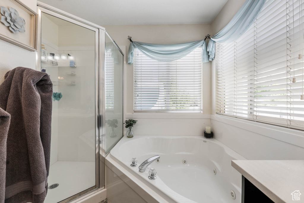 Full bath featuring a shower stall, a tub with jets, and vanity