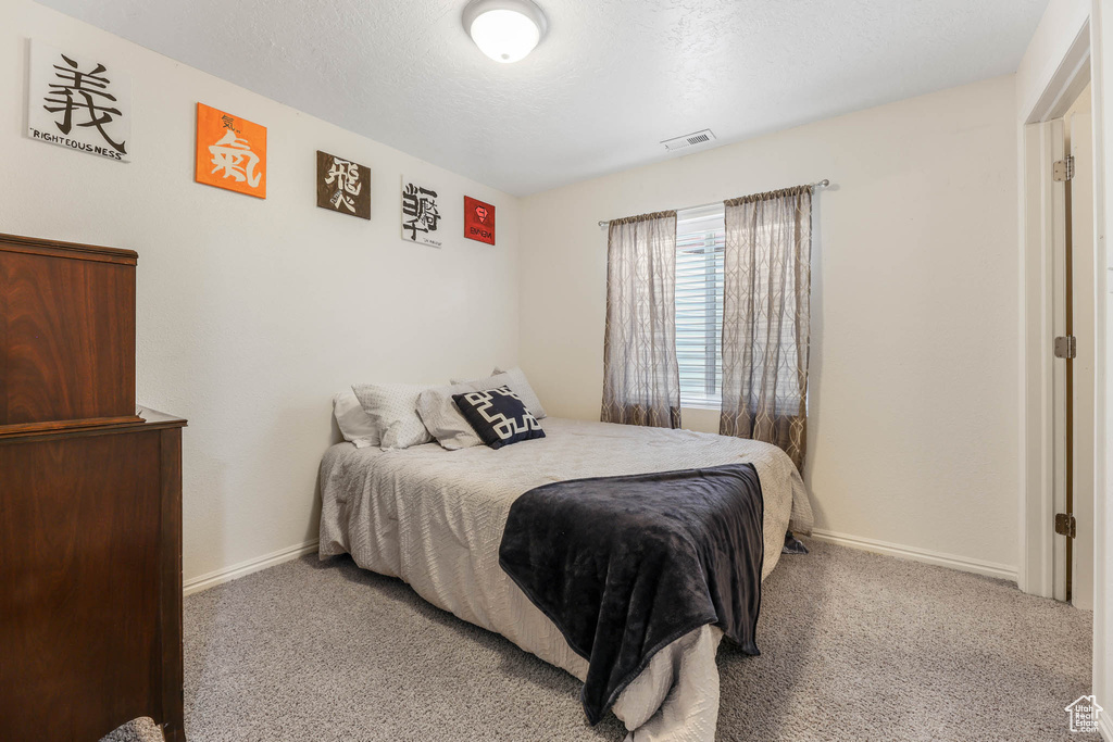 Bedroom featuring carpet and baseboards