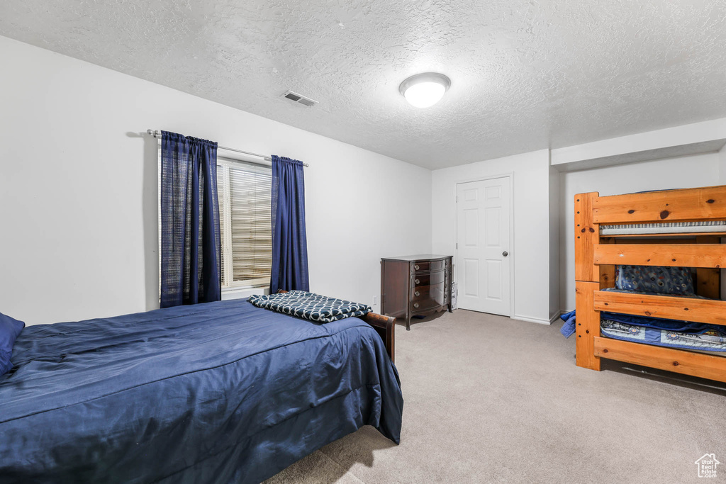 Bedroom featuring carpet and a textured ceiling