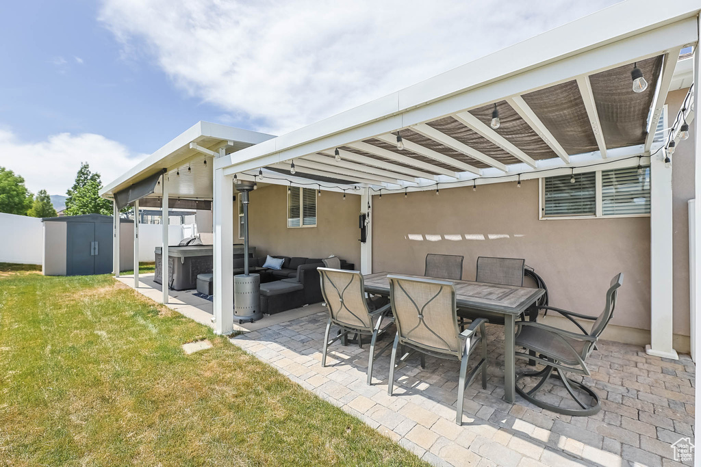 View of patio with a hot tub, an outdoor hangout area, and outdoor dining area