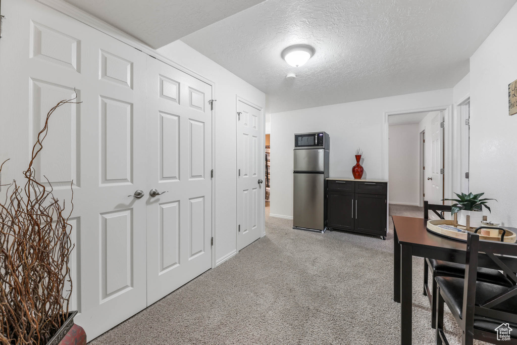 Dining room featuring light carpet and a textured ceiling