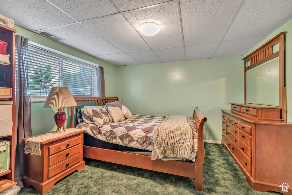 Bedroom with a paneled ceiling and carpet floors