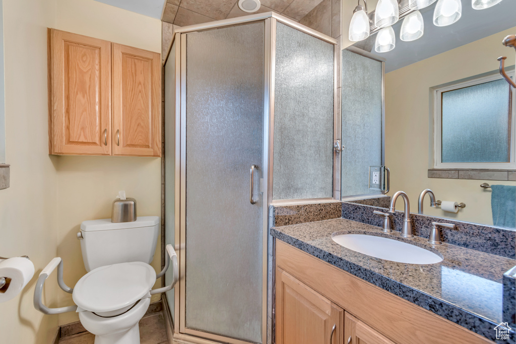 Full bath featuring vanity, a stall shower, and tile patterned floors