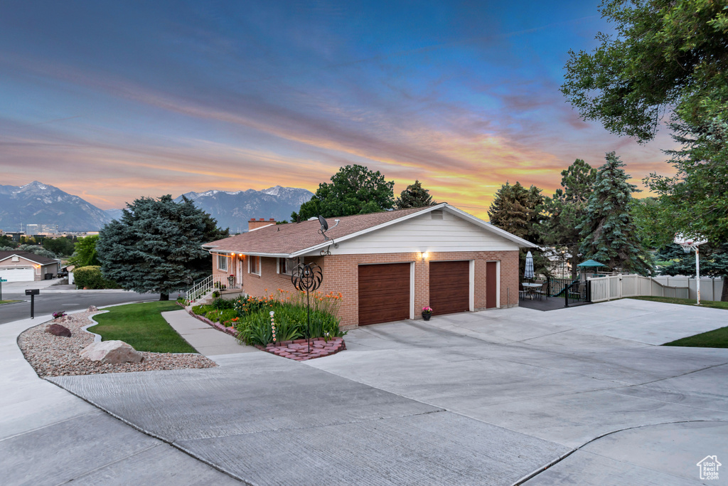 View of front facade with a mountain view, a garage, and driveway