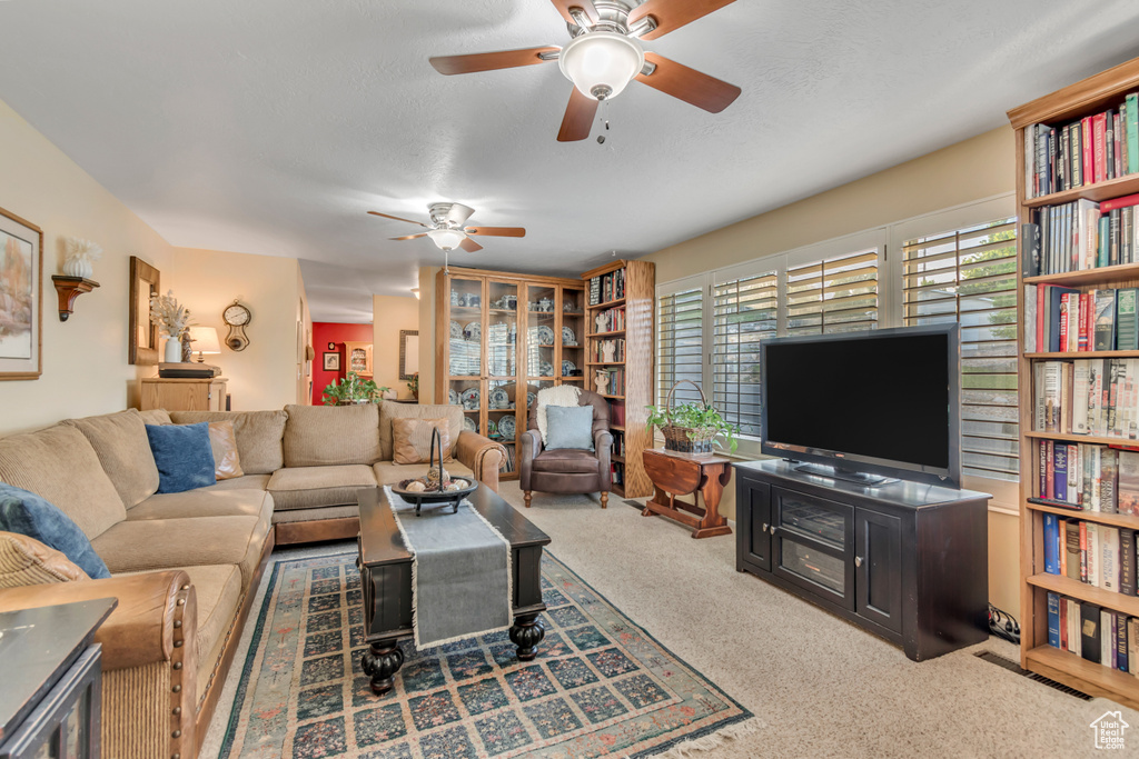 Living area featuring ceiling fan and carpet flooring