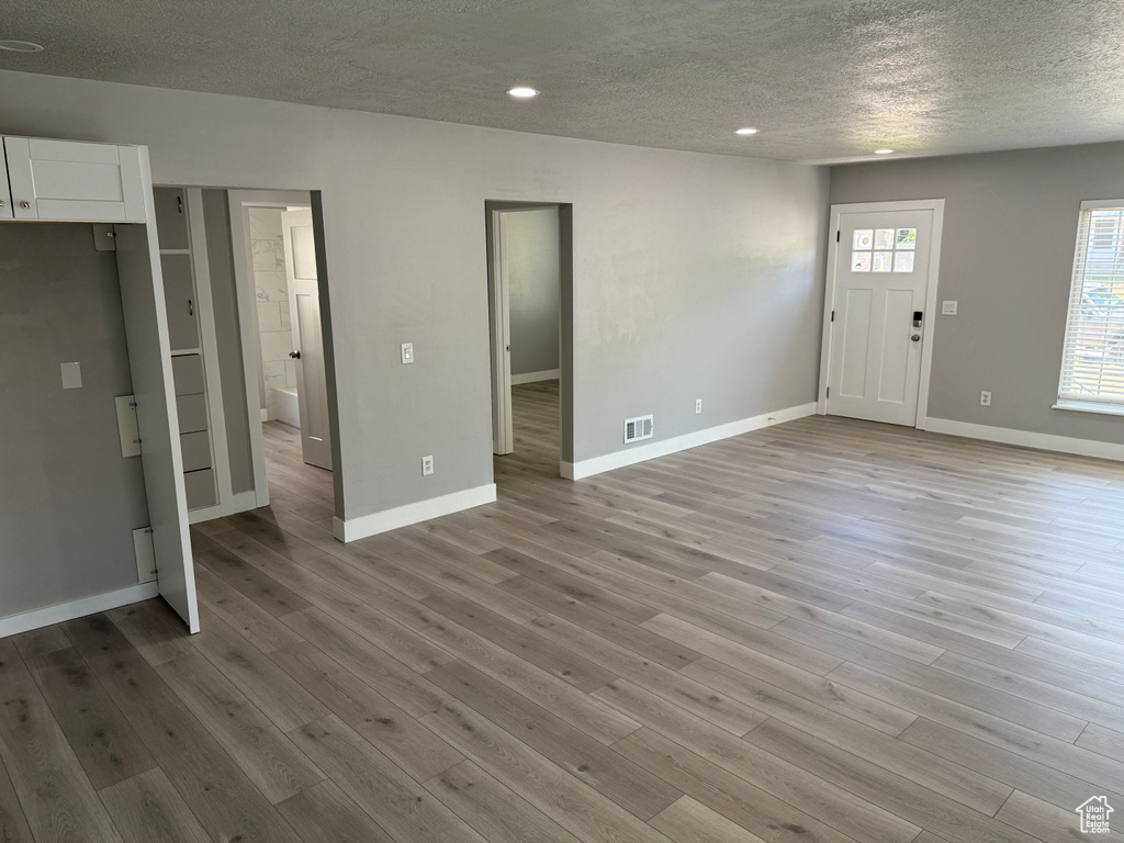Entrance foyer with a textured ceiling, light wood-style floors, and recessed lighting