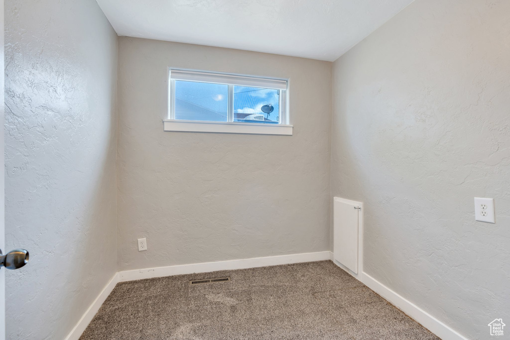 Spare room with carpet and a textured wall