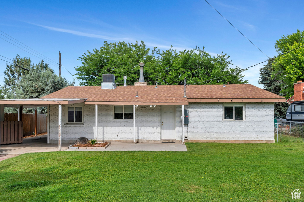 Rear view of property with brick siding, a patio, and roof with shingles