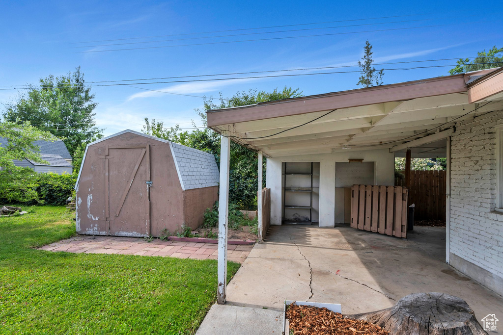View of parking / parking lot with a shed and a carport