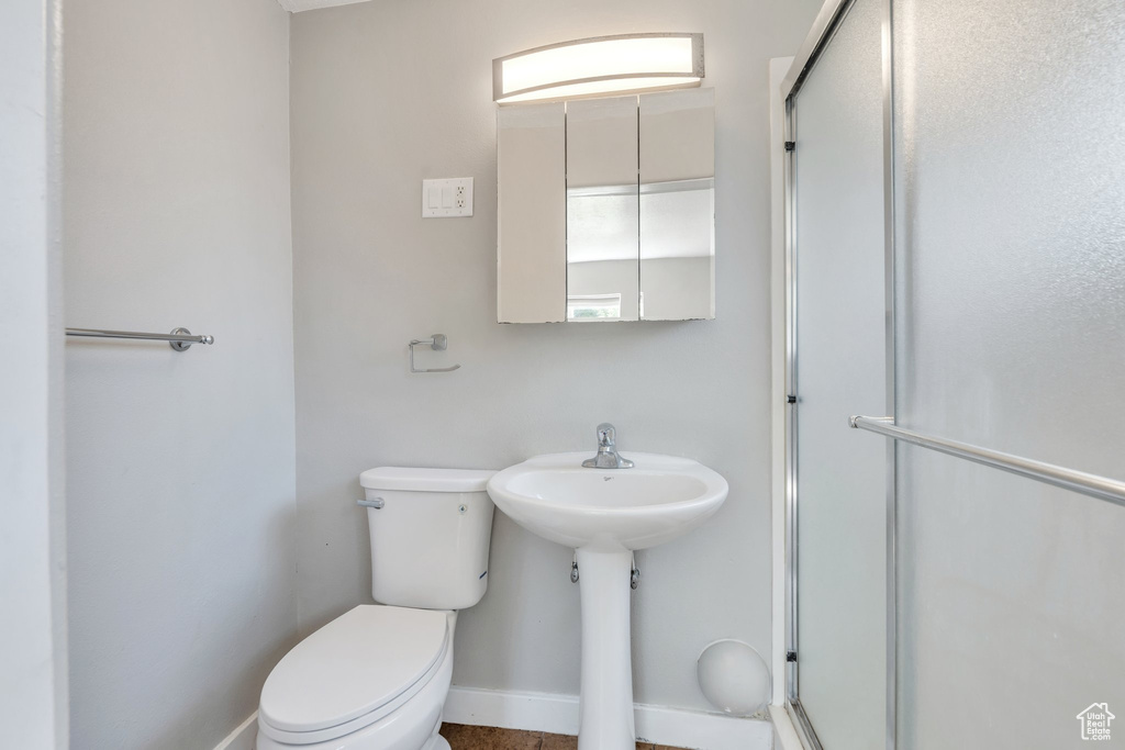 Full bathroom featuring toilet and a shower stall