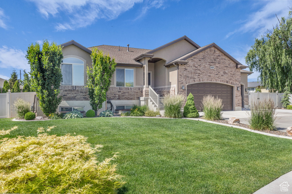 Single story home featuring stucco siding, a garage, driveway, and brick siding