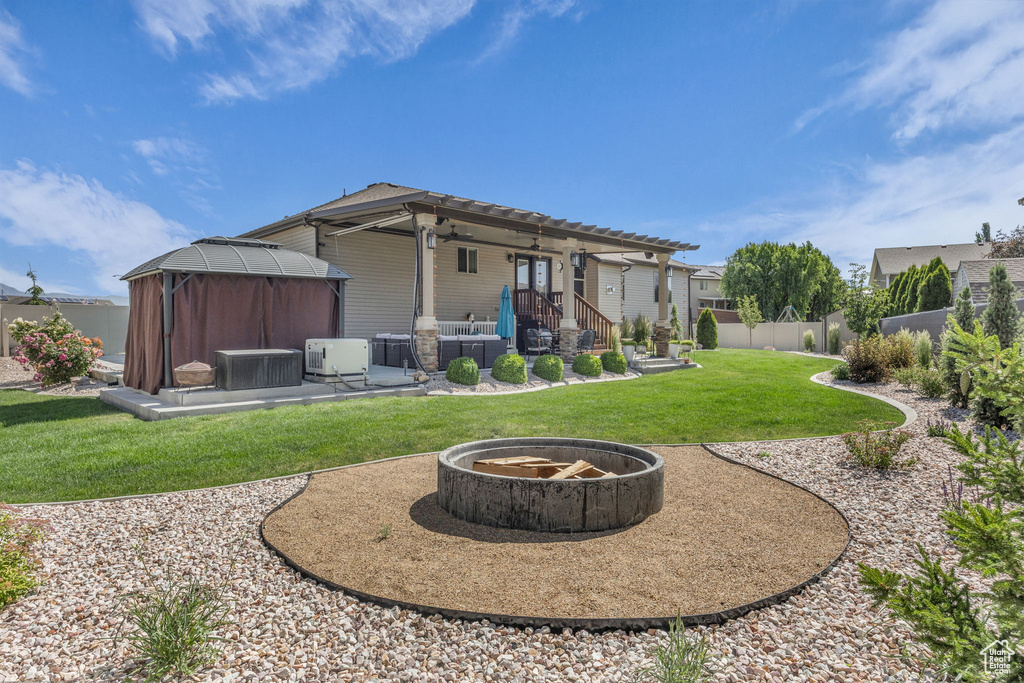 Rear view of house featuring a gazebo, an outdoor fire pit, and a patio