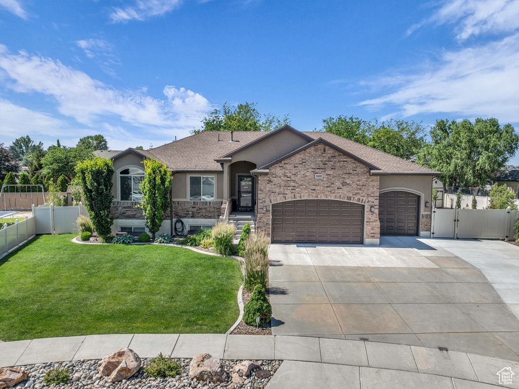 Single story home with stucco siding, concrete driveway, an attached garage, a gate, and roof with shingles