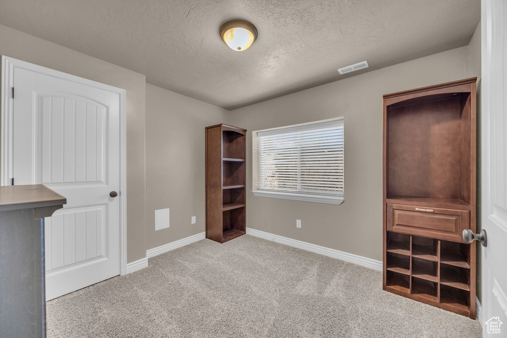Unfurnished bedroom featuring carpet and a textured ceiling