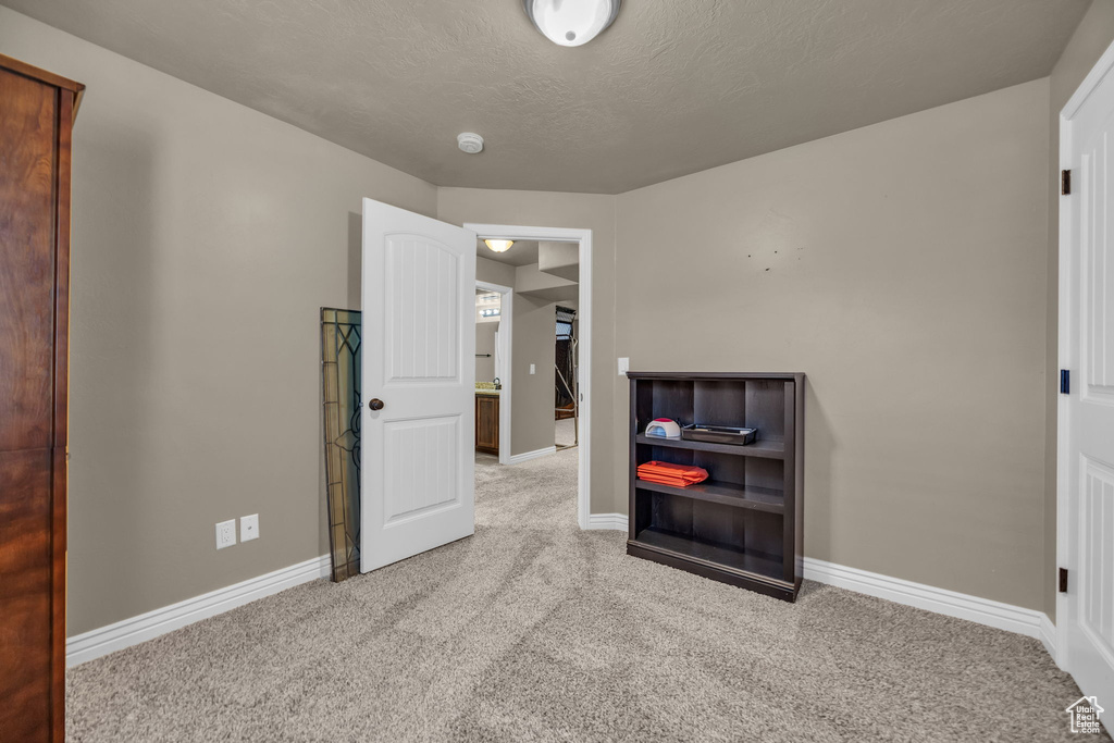Unfurnished bedroom featuring carpet floors and a textured ceiling
