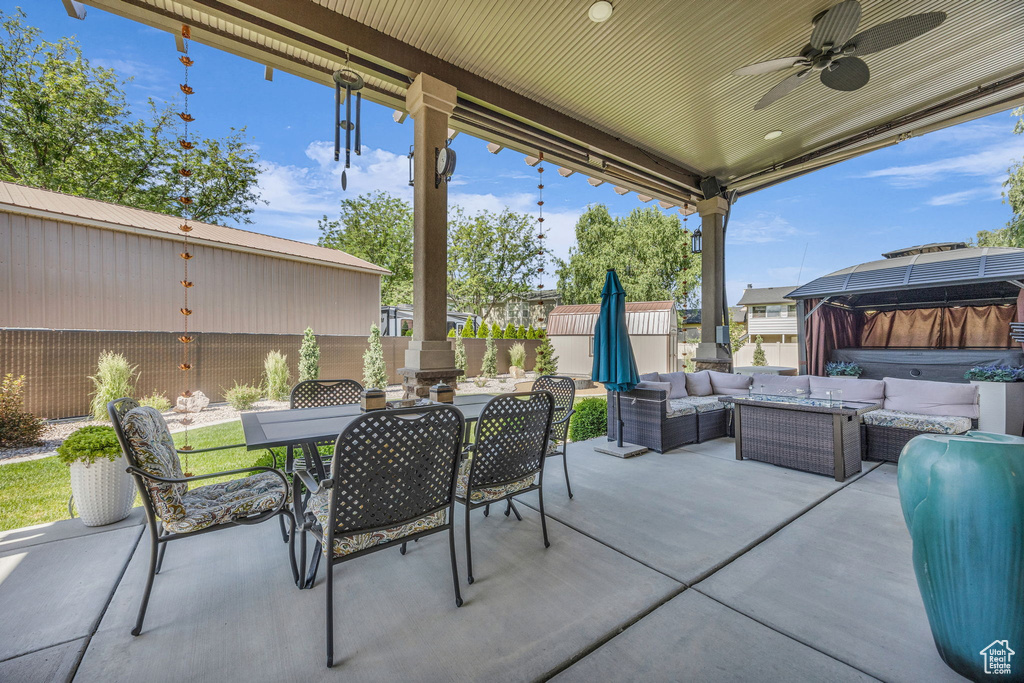 Fenced backyard with a hot tub, an outdoor hangout area, outdoor dining area, and a patio area