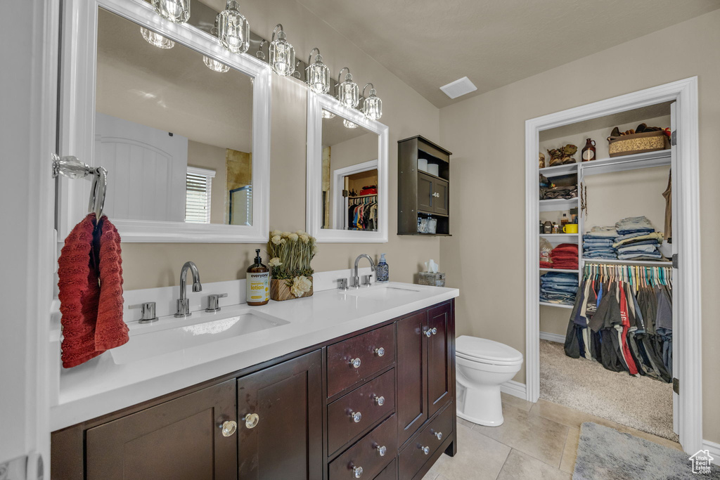 Full bath with double vanity and a walk in closet