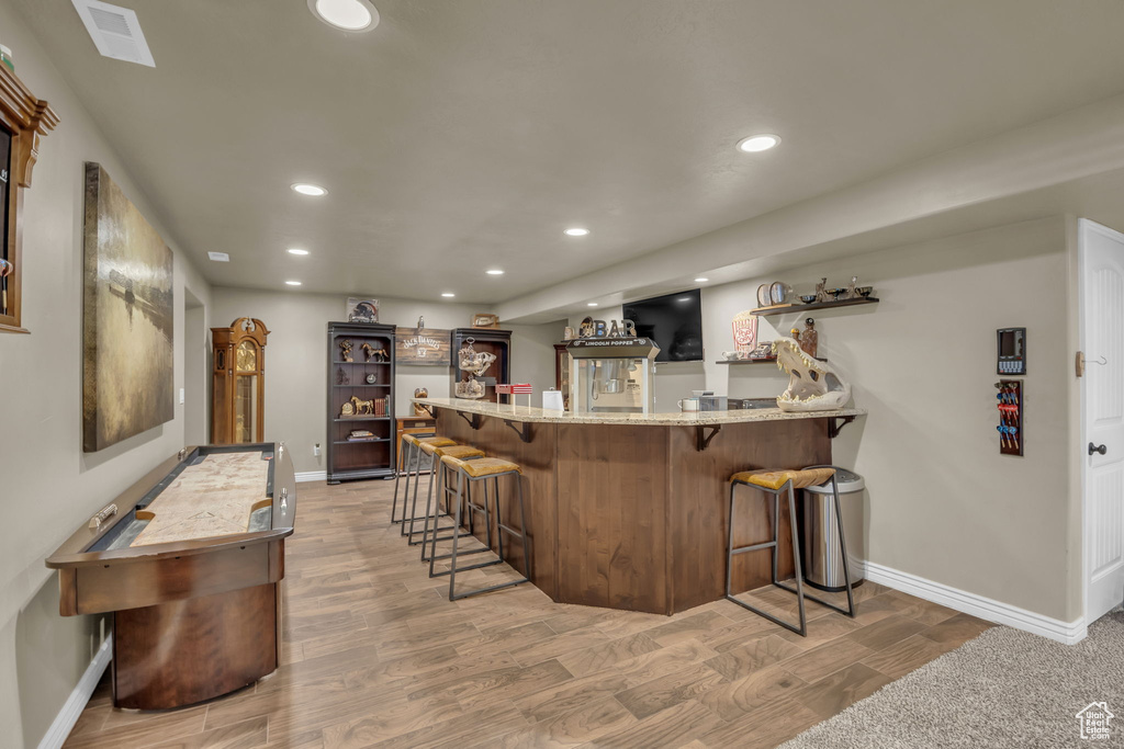 Indoor wet bar featuring recessed lighting and light wood-type flooring