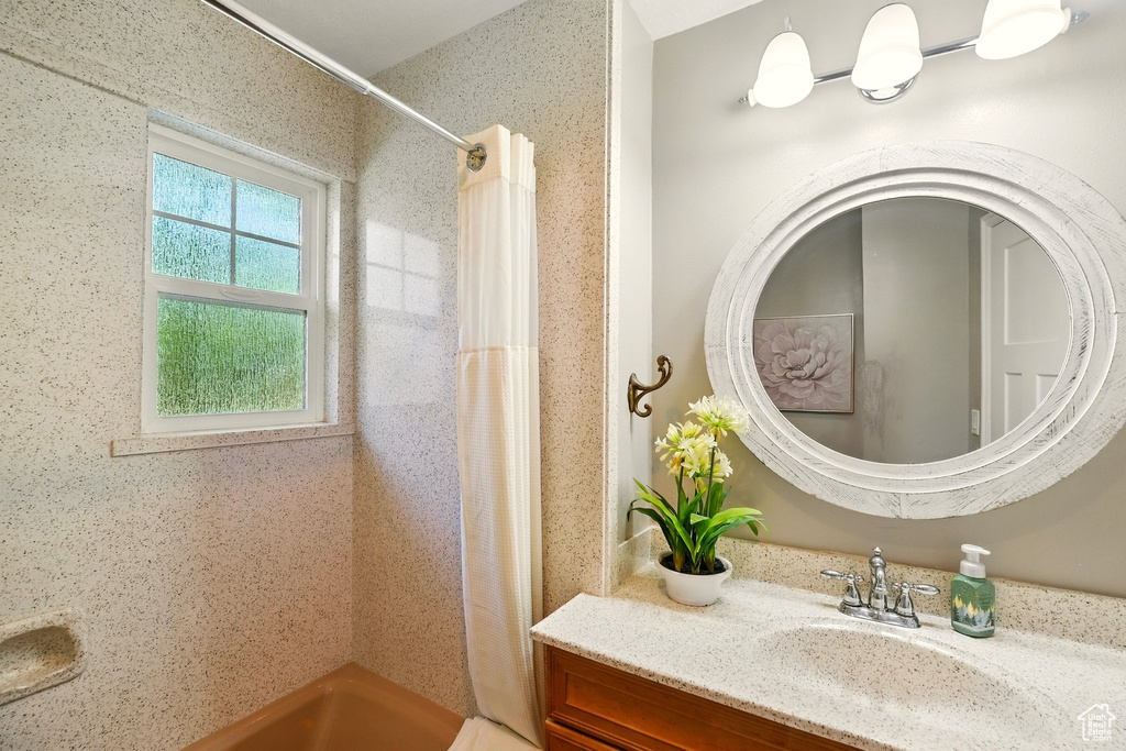 Full bath with a shower with curtain and vanity