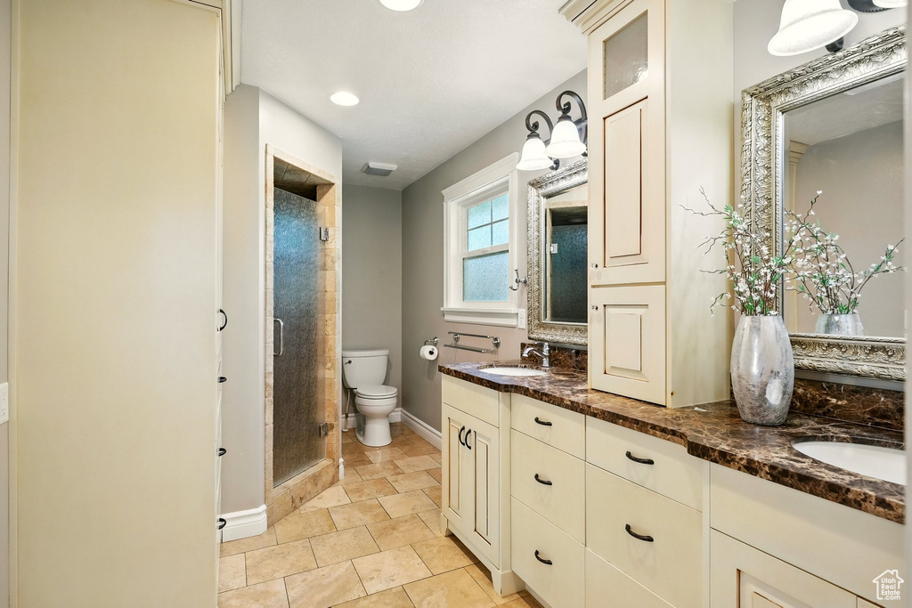 Full bathroom with double vanity, a shower stall, and recessed lighting