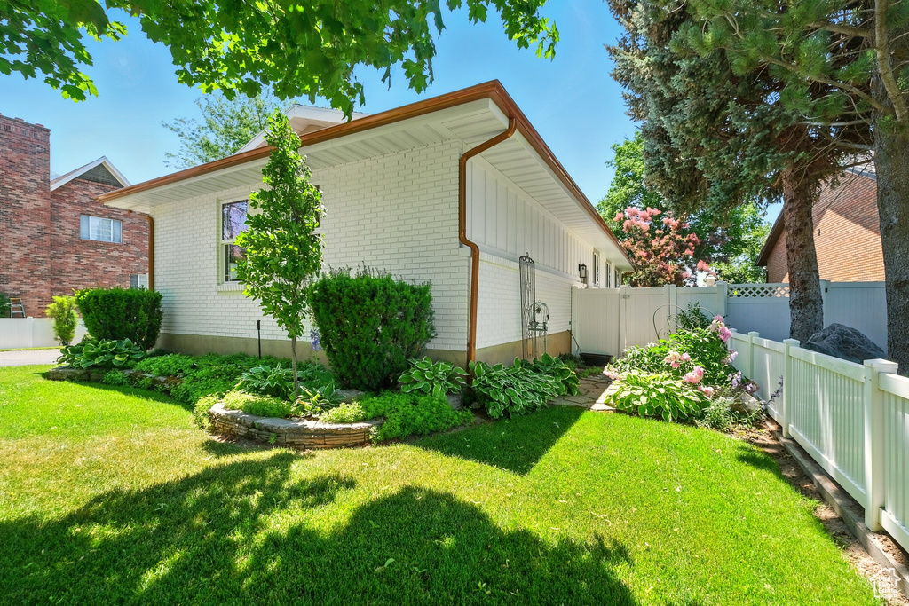 View of side of home featuring brick siding and a fenced backyard