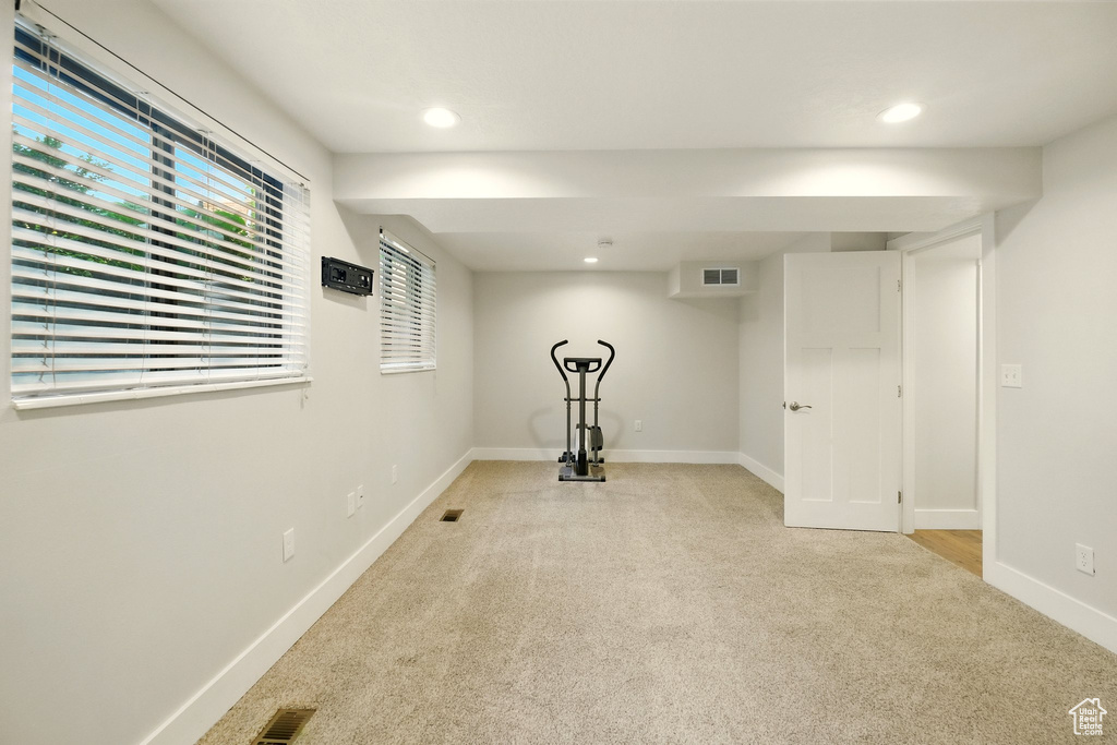 Workout room with light colored carpet and recessed lighting