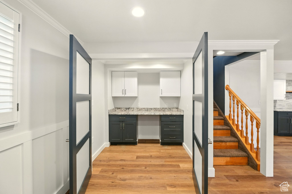 Kitchen with white cabinetry, light wood-style flooring, light stone countertops, and recessed lighting