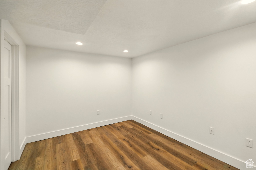Empty room featuring recessed lighting and dark wood-type flooring
