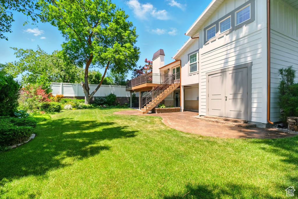 View of yard featuring stairway, a wooden deck, and a patio