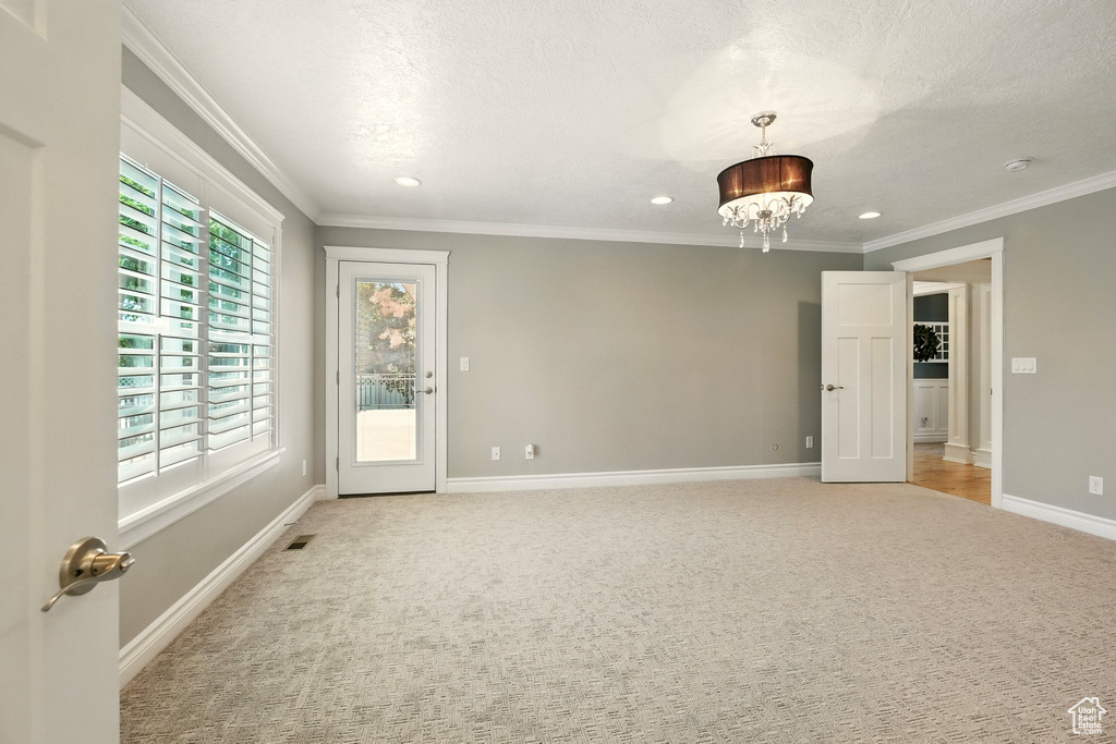 Empty room featuring light colored carpet, recessed lighting, crown molding, a chandelier, and a smoke detector