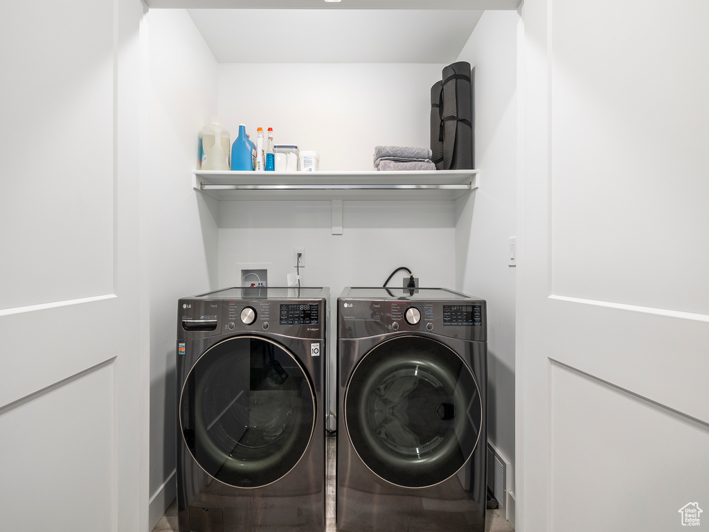 Laundry room featuring washing machine and dryer and baseboards