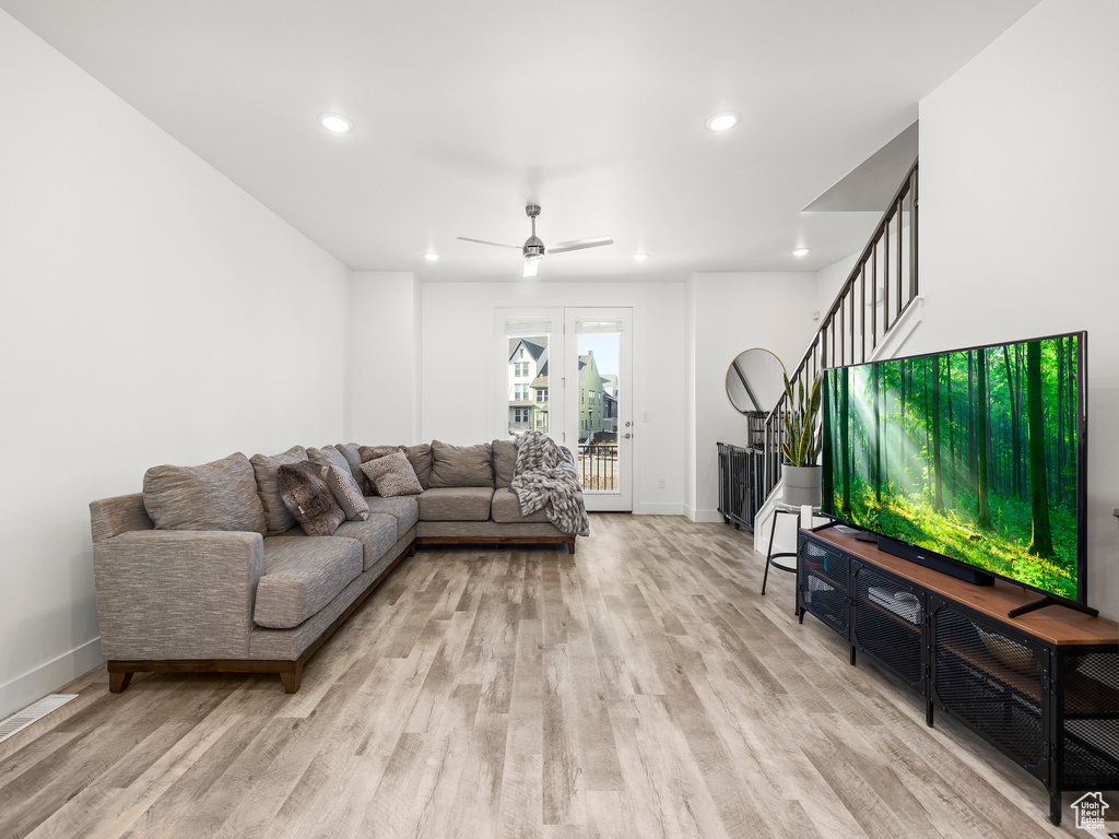 Living area with light wood-type flooring, recessed lighting, stairway, and ceiling fan