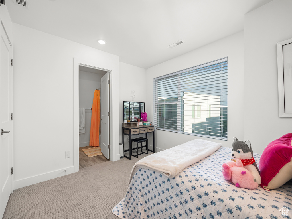 Carpeted bedroom with recessed lighting and ensuite bathroom