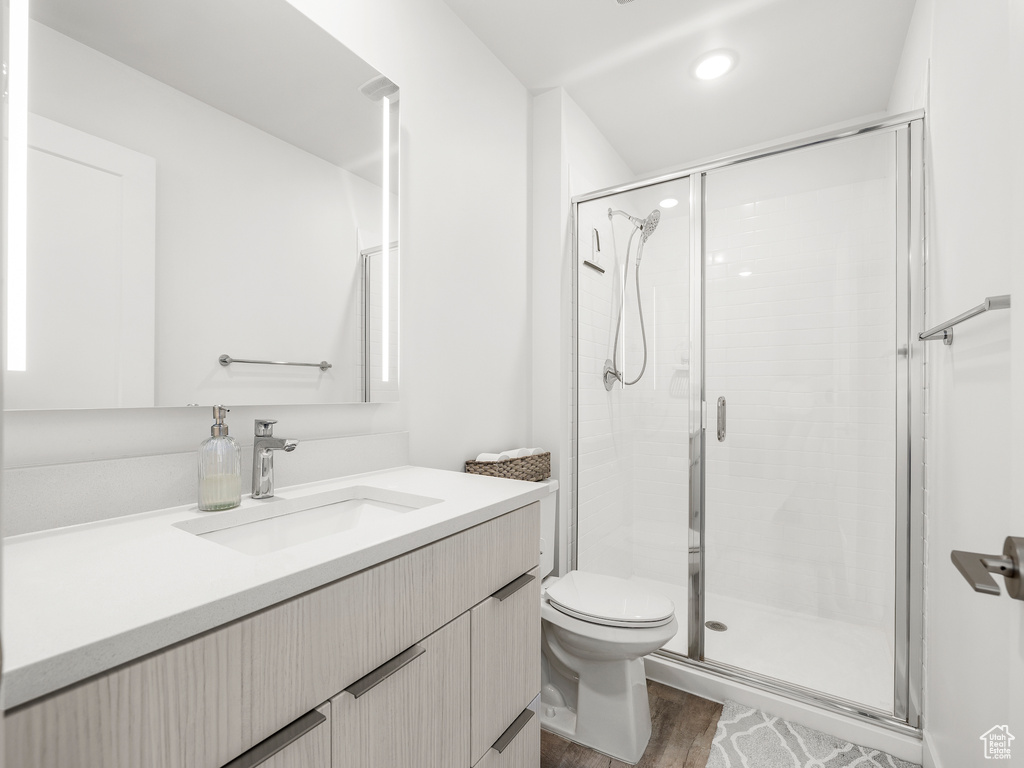 Full bathroom featuring vanity, a shower stall, wood finished floors, and recessed lighting