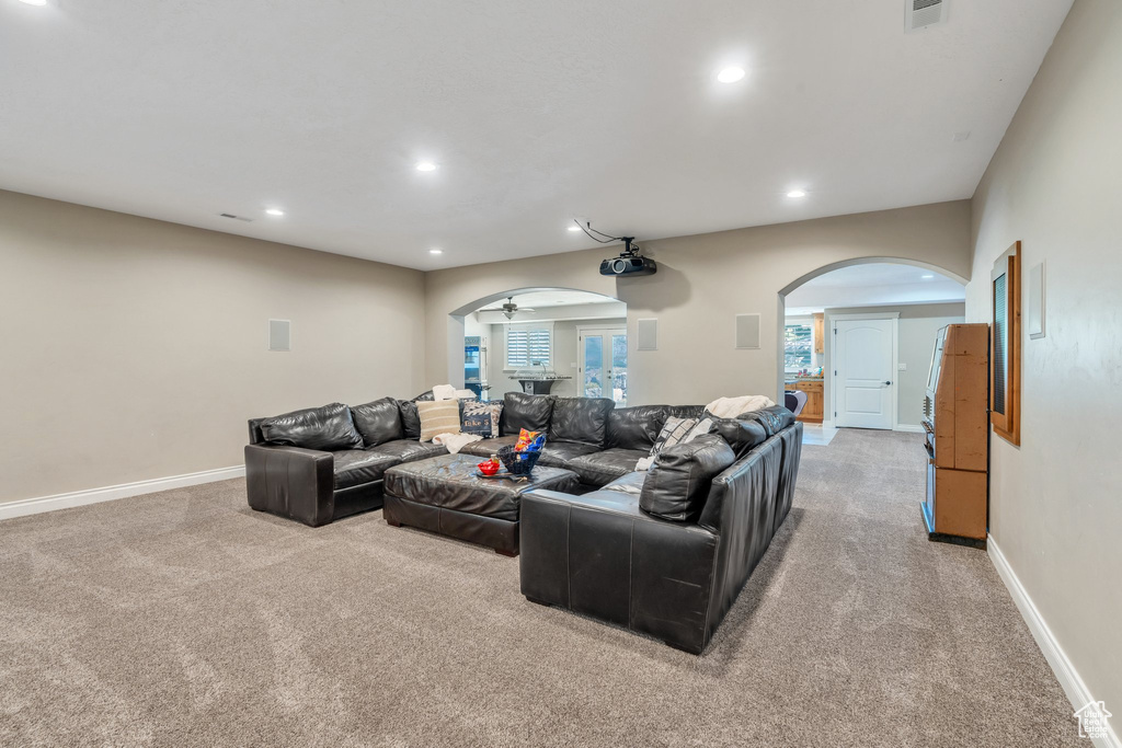 Living area with arched walkways, light colored carpet, recessed lighting, and ceiling fan