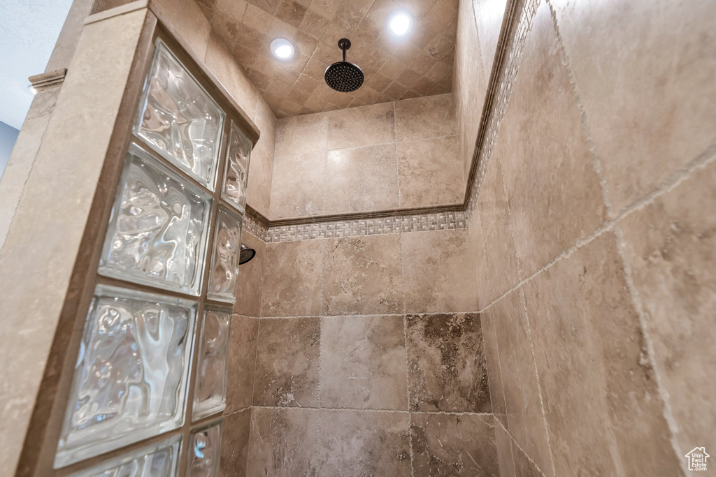 Bathroom view of a tile shower and recessed lighting