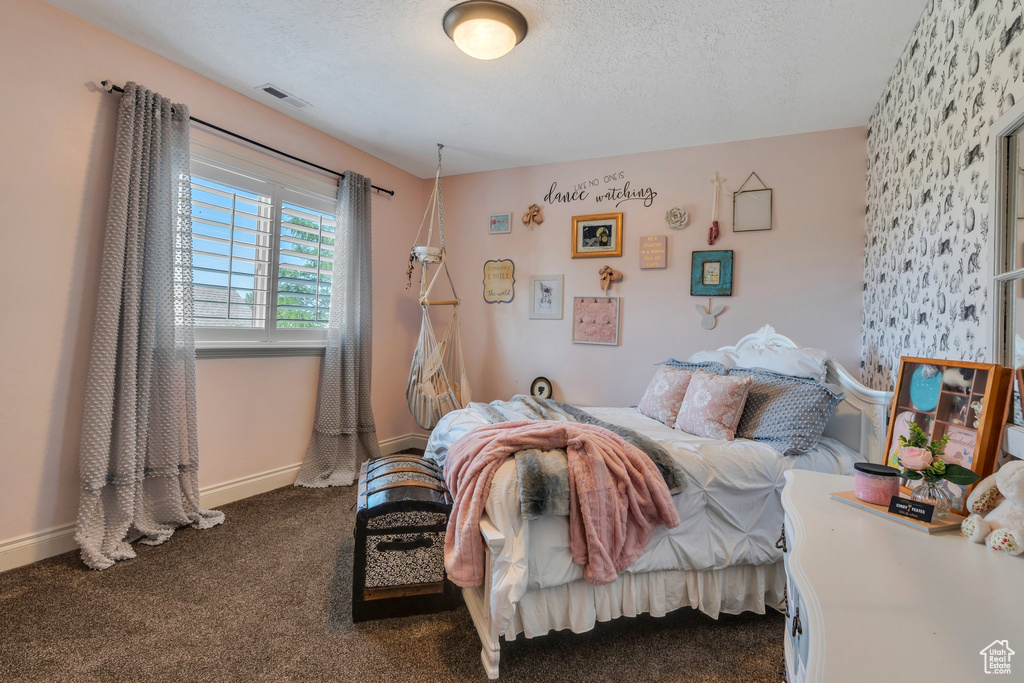 Bedroom featuring a textured ceiling and dark carpet
