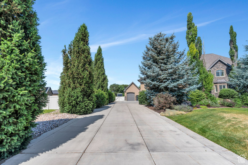 Obstructed view of property featuring a garage, a front lawn, and a gate