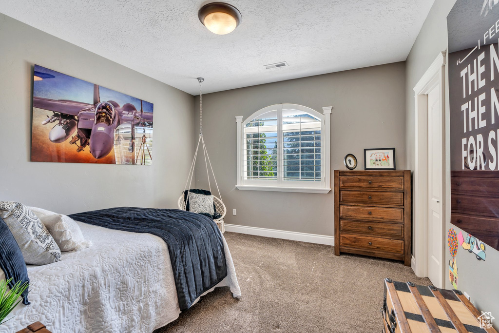 Bedroom featuring carpet floors and a textured ceiling