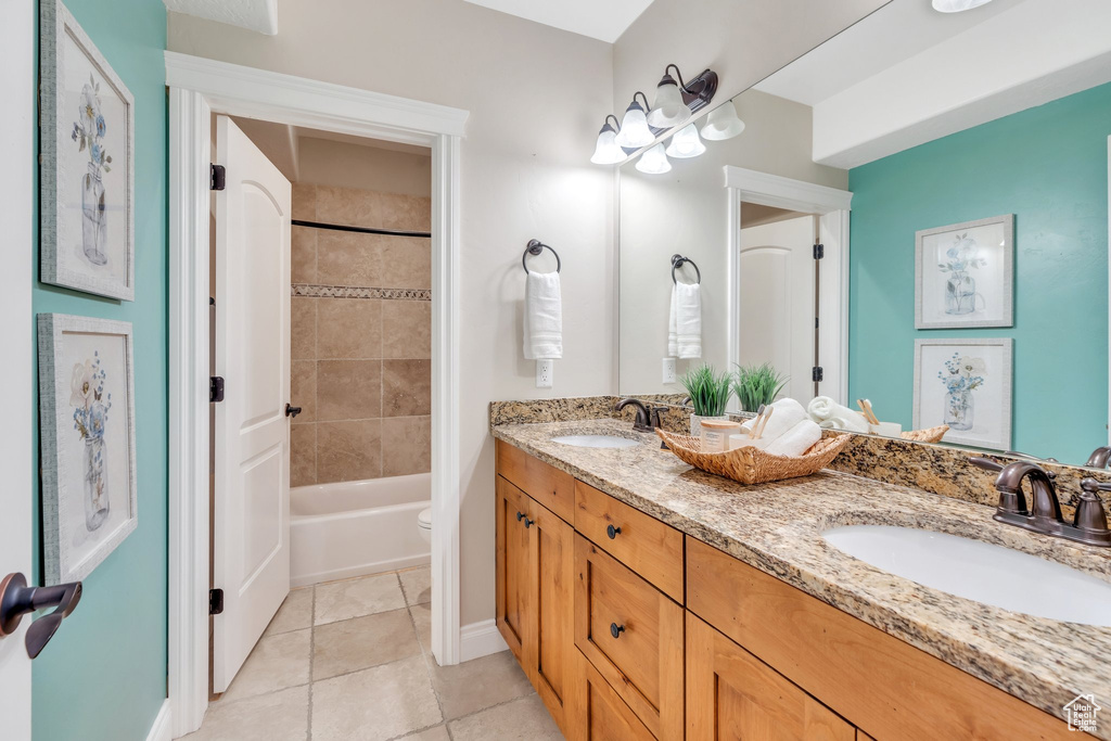 Full bathroom with double vanity, tile patterned flooring, and  shower combination