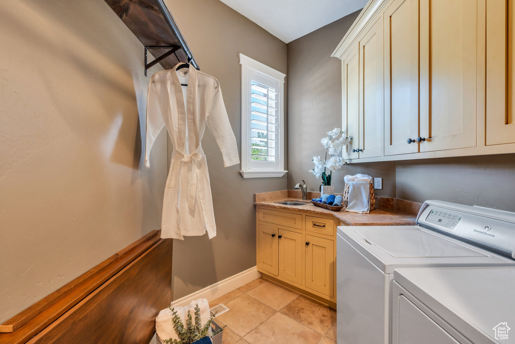Laundry area with cabinet space, washer and clothes dryer, and light tile patterned floors