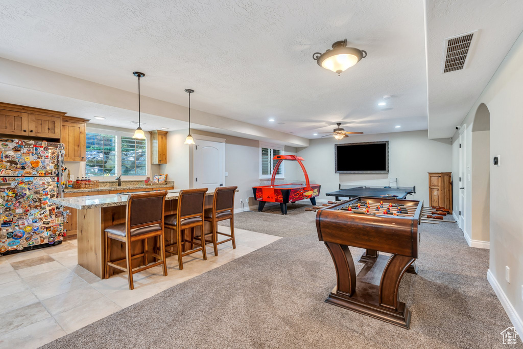 Recreation room featuring ceiling fan, recessed lighting, light carpet, and a textured ceiling