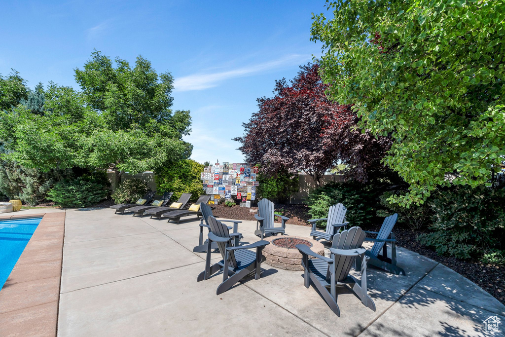 Fenced backyard featuring a fire pit and a patio area