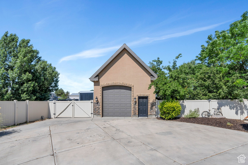Garage featuring a gate and concrete driveway
