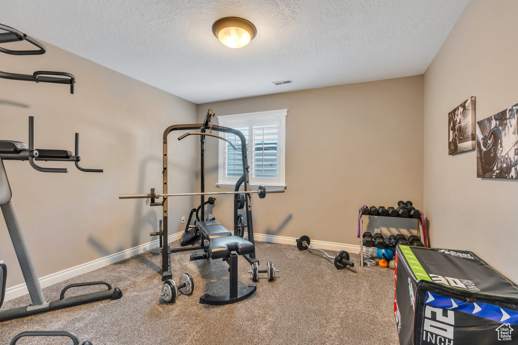 Workout area with a textured ceiling and carpet floors
