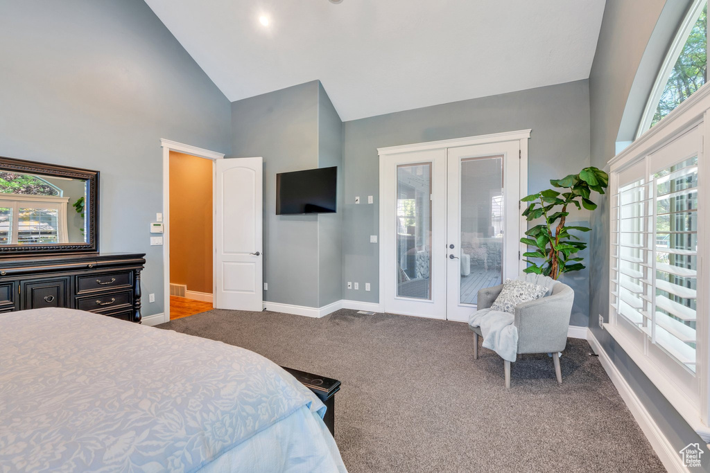 Carpeted bedroom featuring french doors, high vaulted ceiling, and access to exterior