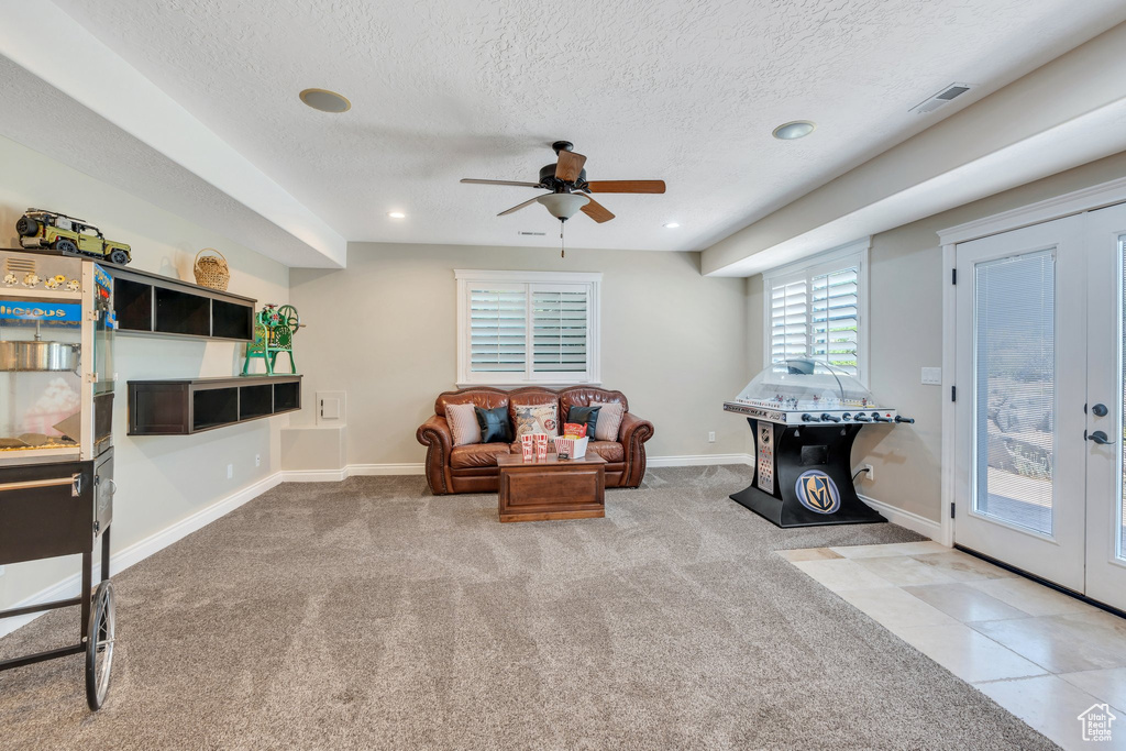 Carpeted living room with ceiling fan, a textured ceiling, french doors, and recessed lighting