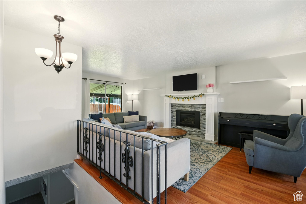 Living area featuring wood finished floors, a fireplace, and a textured ceiling