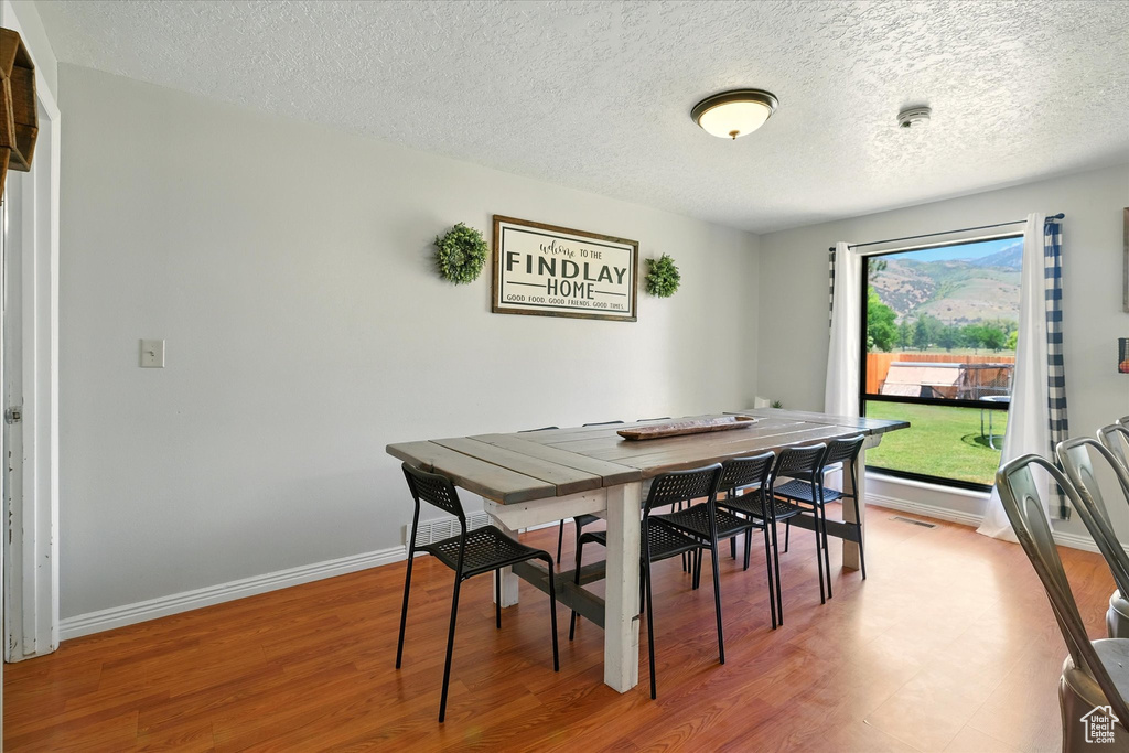 Dining room featuring a textured ceiling and wood finished floors